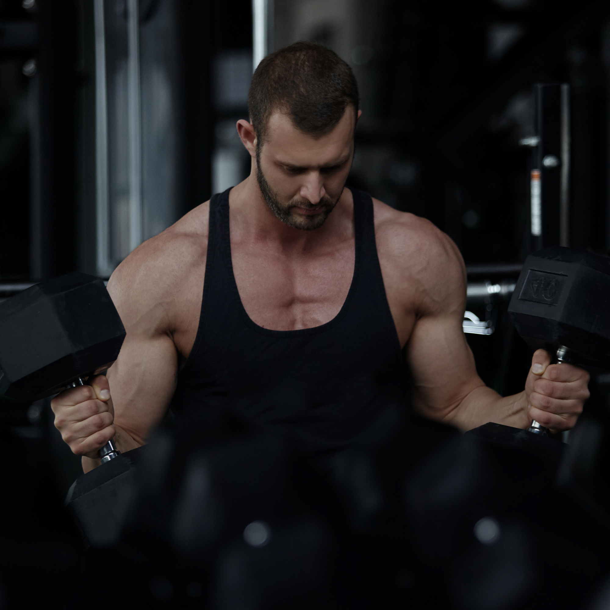 Man exercising with dumbbells in a gym