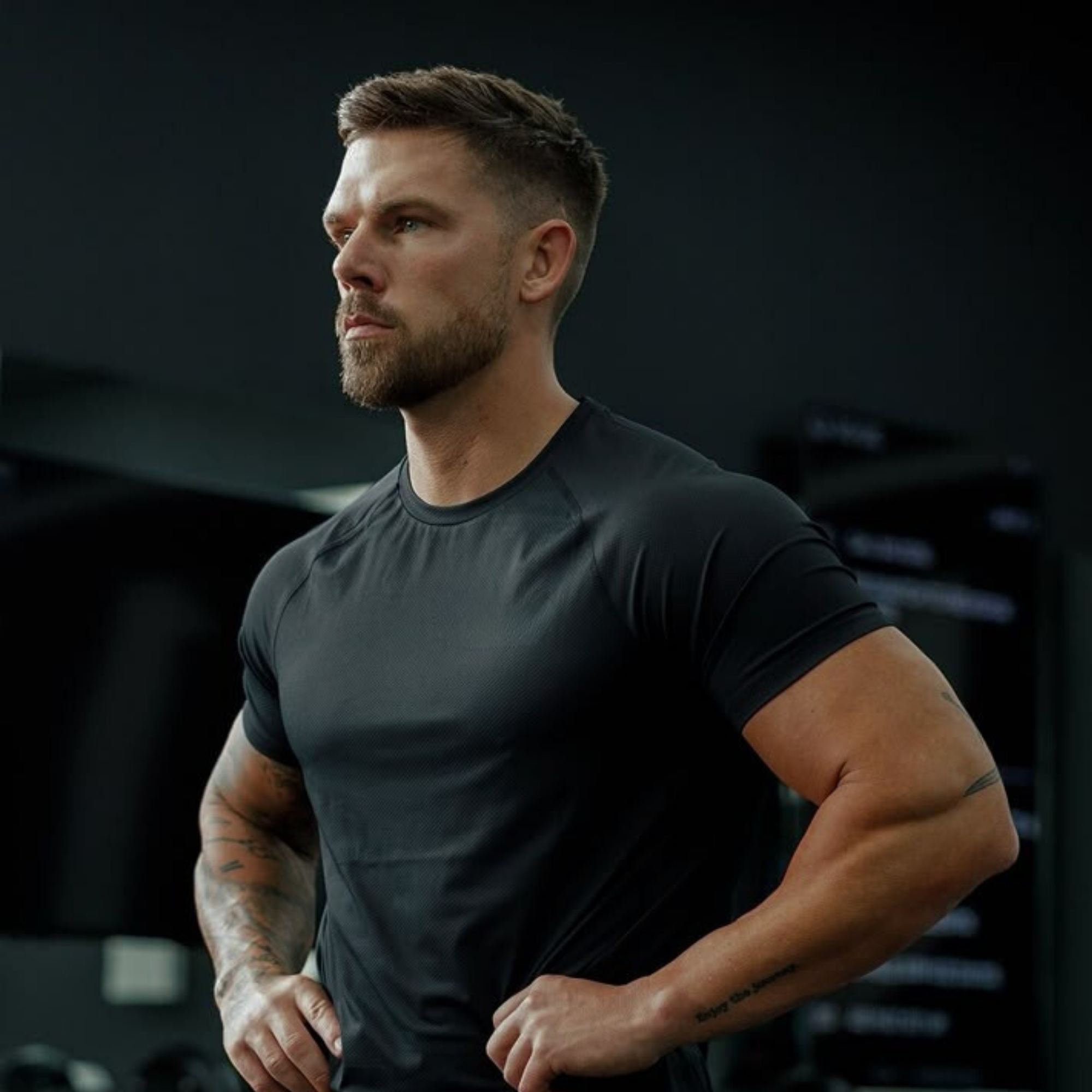 Muscular man in a dark t-shirt standing