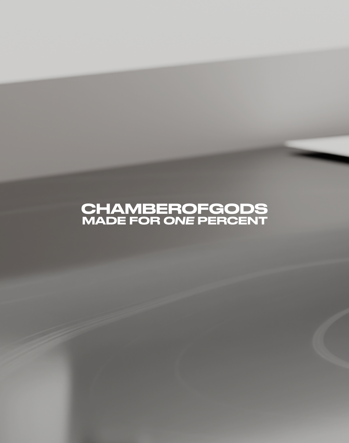 A minimalist design featuring the text 'CHAMBEROFGODS' in bold, followed by 'MADE FOR ONE PERCENT' in a smaller font. The background is a smooth, gradient gray surface with subtle reflections, emphasizing a sleek and premium aesthetic.