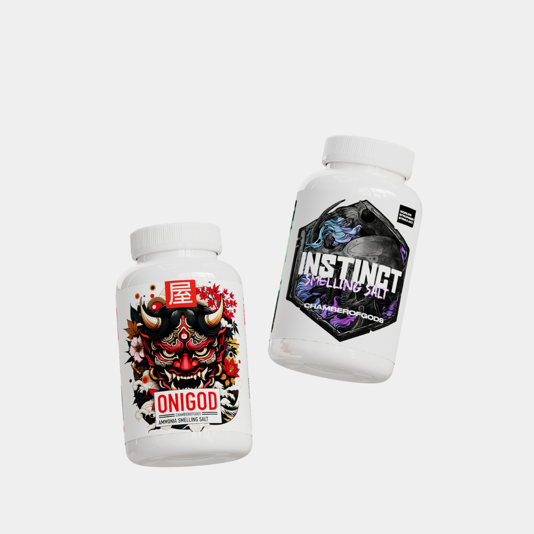 Two white bottles of ammonia-smelling salts against a white background. The left bottle features a vibrant red demon mask design with floral accents and the text 'ONIGOD' below a red square with a white symbol. The right bottle has a black and purple hexagonal label depicting a dragon/serpent, with the text 'INSTINCT SMELLING SALT' and 'CHAMBER OF GODS' beneath it. Both bottles have white caps.